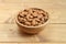 Shelled almonds in bamboo bowl on wooden background