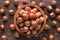 Shelled forest nuts in wooden bowl, top view