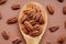 shelled pecans. Pecan nuts in a wooden spoon on a brown background. Keto diet ingredient. Useful healthy snack.