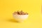 Shelled walnut bowl on yellow background