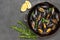 Shellfish Mussels in frying pan.  Rosemary and lemon on table. Shellfish seafood