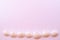 Shells lined in a row on a delicate pink background with copy space. Flat lay.