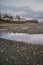 Shells and rocks lie exposed in a saltwater lagoon during low tide on Vancouver Island, Canada.