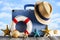 Shells and starfish, summer hat, lifebuoy and travel bag on beach
