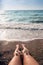 Shells on the woman`s feet at the sea shore