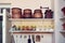 Shelves of an antique rural kitchen with vintage earthenware pots, coffee grinder and jars