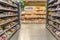 Shelves with groceries in the supermarket. Large selection in the bread department. Blurred