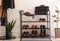 Shelving rack with stylish shoes and accessories near brick wall indoors