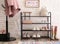 Shelving rack with stylish women`s shoes and accessories near white wall indoors