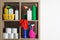 Shelving unit with detergents and toilet paper on white background, space for text