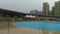 Shenzhen, China: It`s sunny, it`s rainy, men and women in the swimming pool either swim or take shelter from the rain