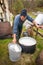 Shepherd preparing milk for cheese making at the farm in Transylvania Roumania