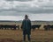 A shepherd standing in front of a herd of cattle. AI generative image.