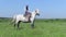 Shepherd on white horse looking at camera