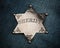 Sheriff star badge on blue denim background