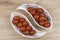 Sherry tomatoes in a porcelain bowl on wooden background