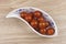 Sherry tomatoes in a porcelain bowl on wooden background