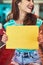 Shes behind this message. an attractive young woman holding up a sign in a retro diner.