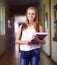 Shes a diligent student. a young girl in her school hallway.