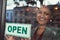 Shes eager to welcome all her customers. Portrait of a young business owner hanging up an open sign on the window of her