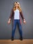 Shes excited about something. a young woman standing against a gray background.