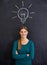 Shes full of ideas. an attractive young woman standing in front of a blackboard.