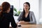 Shes going to ace her interview. two young professionals having a discussion at a desk.