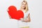 Shes got her heart on her sleeve. A gorgeous young blonde woman holding a heart while isolated on a white background.