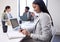 Shes always highly organised. Shot of a young businesswoman working on a laptop and writing notes during a meeting in an