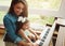 Shes an inquisitive little one. a mother playing the piano with her adorable little daughter at home.