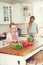 Shes making her favourite meal. A little girl making a salad in the kitchen with her mother standing nearby.