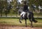 And shes off. Rearview shot a young female jockey riding her horse out on the farm.