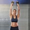 Shes reaching for even greater heights. Cropped portrait of a young woman working out with kettle bells at the gym.