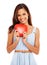 Shes a true romantic. Young woman holding a red heart and smiling against a white background.