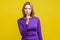 Shh, be quiet! Portrait of serious woman in tight purple dress showing silence gesture. isolated on yellow background