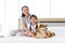 Shiba Inu lying on bed with mother and daughter.