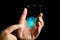 Shield icon on the thin screen of futuristic transparent glass smartphone in hand