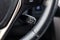 The shift lever to set the automatic cruise control speed inside the car close-up located near the steering wheel in black with
