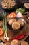 Shiitake mushrooms with garlic, tomato, capsicum, spring onion and red onions on a black cement floor