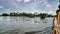 Shikara boat on water with coconut trees and sky