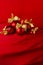 Shimmer glitter glossy red balls with gold bows on deep scarlet silky smooth wavy background, copy space, vertical. Luxury New.