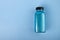 Shimmering bath salt in bottle, shiny blue cosmetics, bright cosmic sparkles, copy space