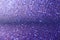 Shimmering purple sandy background with blur. Macro image of a metallic shiny surface with textured lines