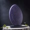 shimmering violet oval with intricate details carved from slate podium, empty showcase for packaging product