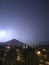 Shine and thunderstorm above mountain and city