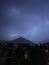 Shine and thunderstorm above mountain and city