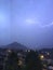 Shine and thunderstorm above mountain and city
