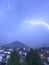 Shine and thunderstorm above mountain and city