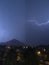 Shine and thunderstorm above mountain and city