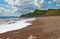 The shingle beach at Eype in Dorset on a sunny day, The sandstone cliffs of the Jurassic coast can be seen in the background